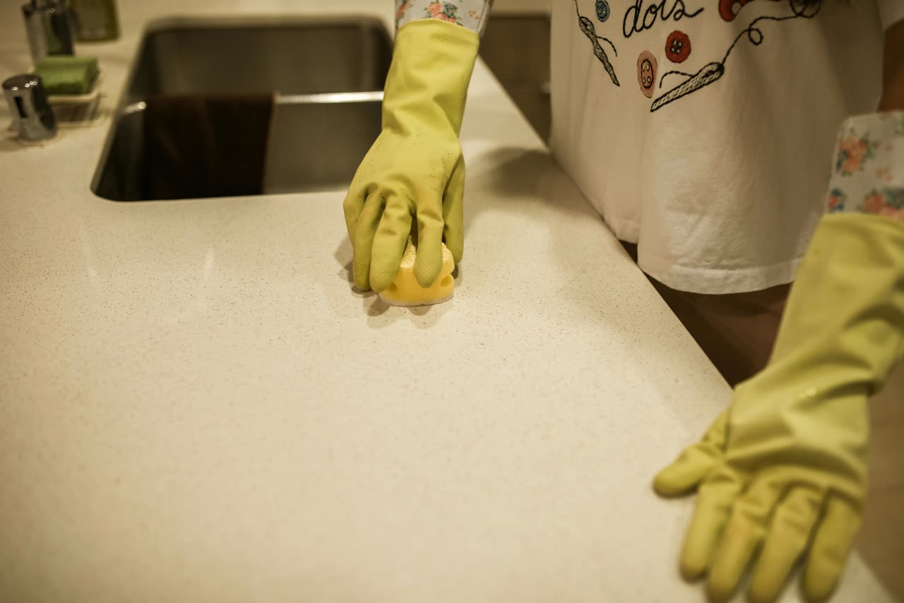 Professional cleaner wiping a bright kitchen counter for NKAY CLEANING